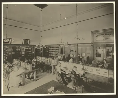 Interior of a public library with readers at long tables