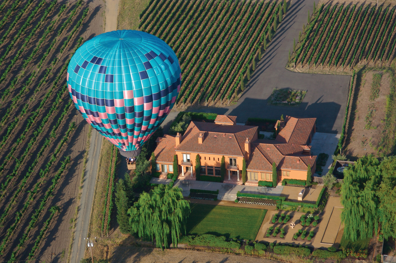Hot air balloon over vineyard estate with garden — historic image