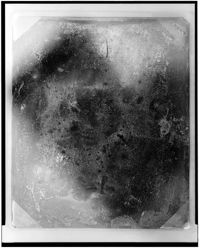 Severely corroded daguerreotype plate with mottled dark surface