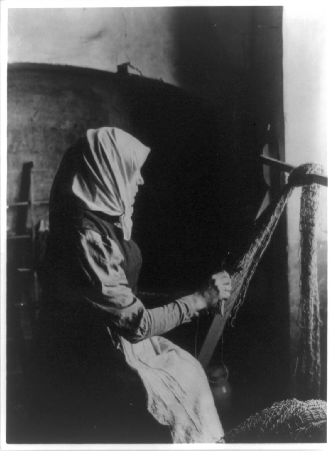 Woman mending fishing net, Lithuania, [between 1890 and 1923] — historic photograph