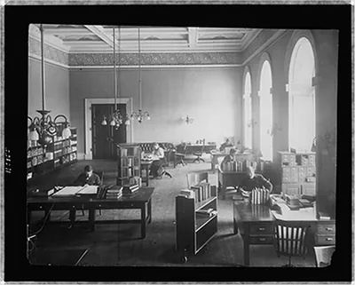 [Five people working in a reading room(?) of the Library of Congress]