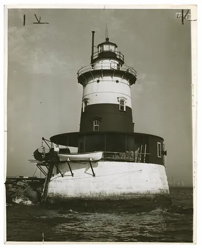 Lighthouse on stone base with lantern tower and boat