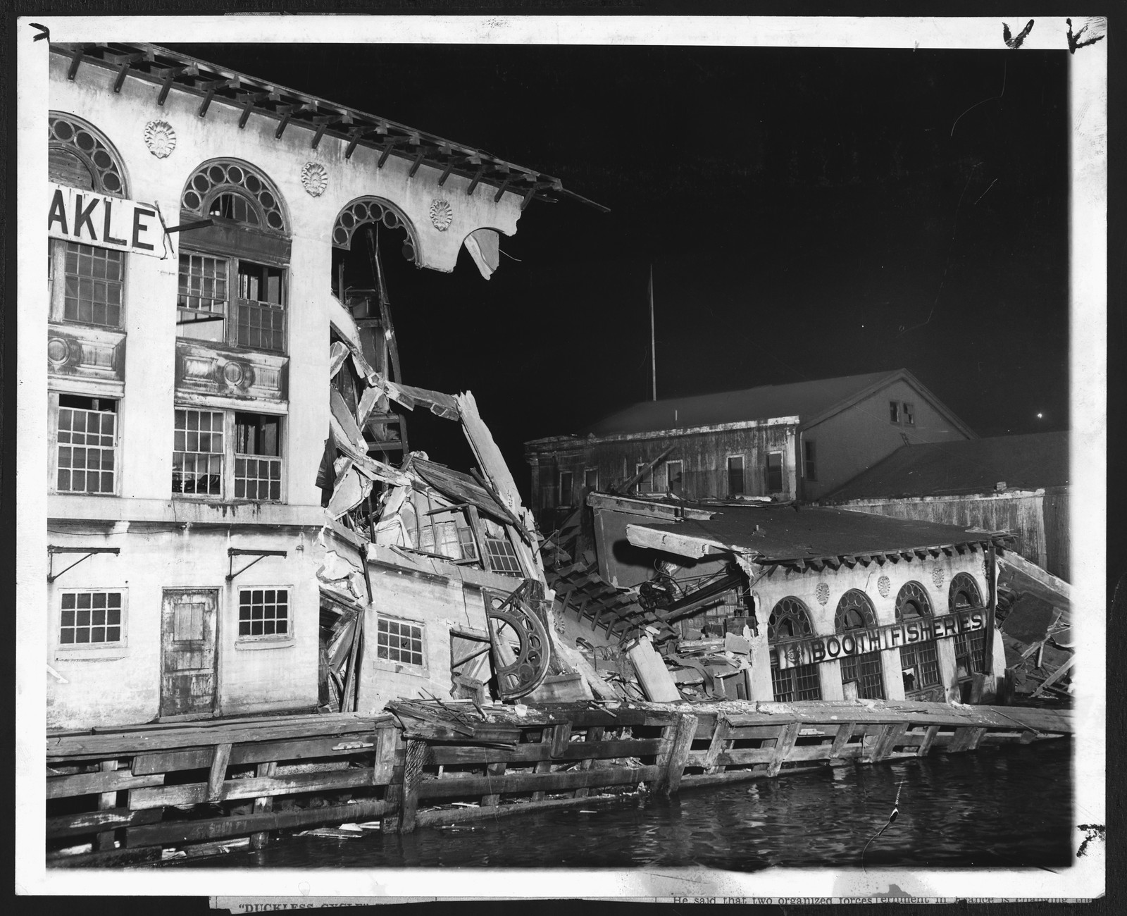 Collapsed fish market building sliding into water at night — historic image