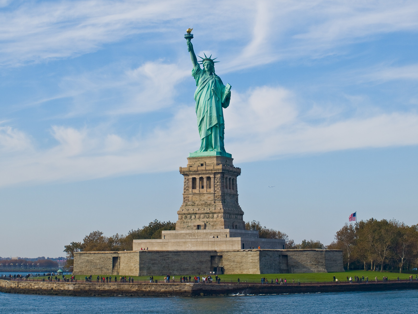 Statue of Liberty on its island pedestal with visitors — historic image