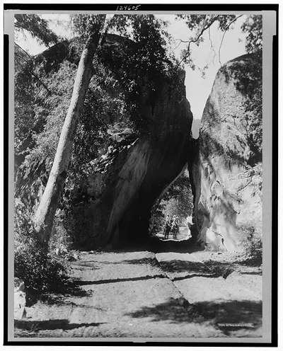[Horse drawn carriage coming through Arch Rock, a large rock formation in the valley of Yosemite National Park]
