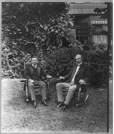 [Theodore Roosevelt, full length, seated in chair on lawn, facing slightly right, with Senator Charles Warren Fairbanks, at Sagamore Hill, Oyster Bay, N.Y.]