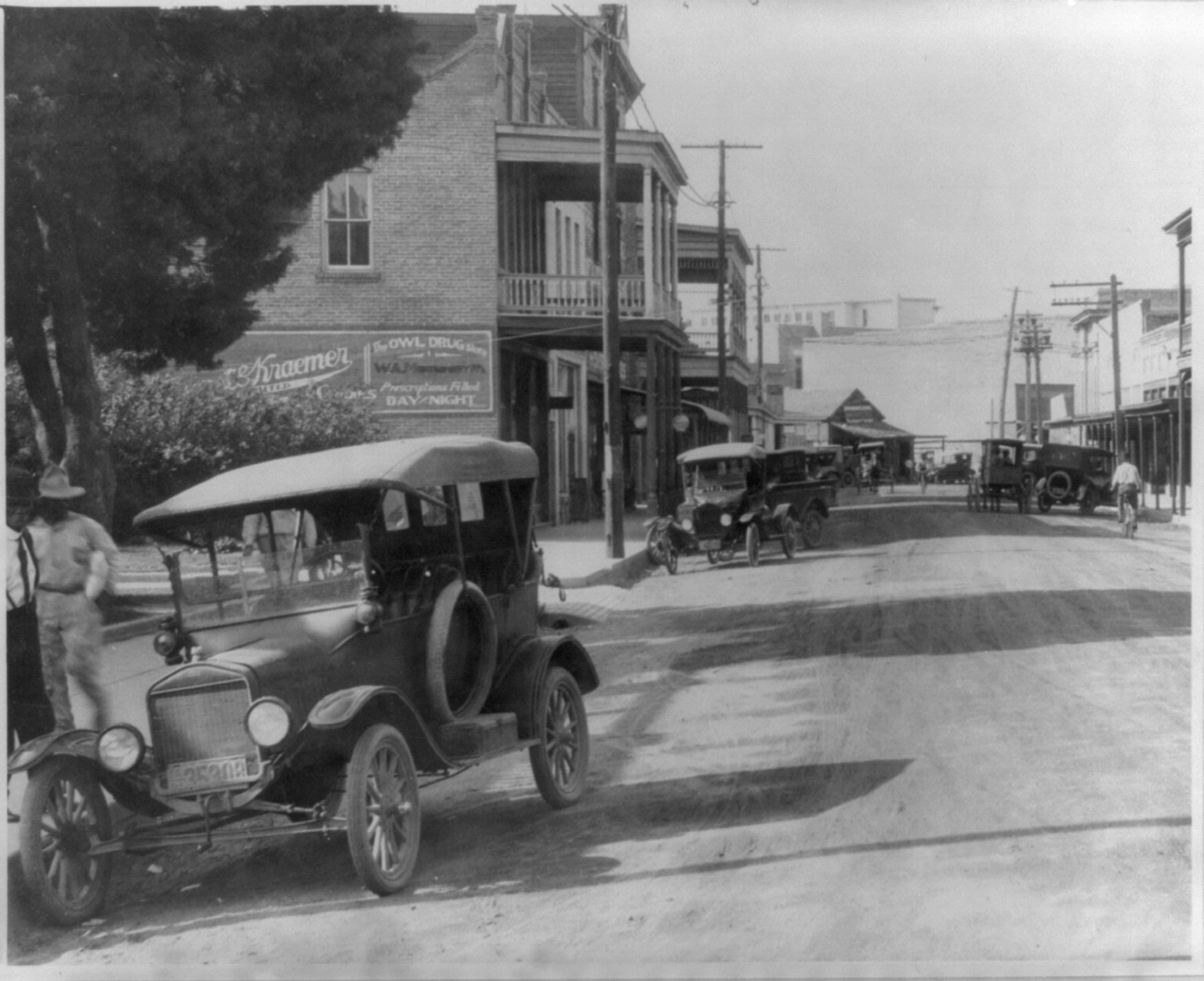 Ford automobile parked on street, with buildings and other autos in background, Lafayette, La., 1921 — historic photograph