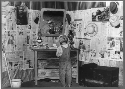 Southeast Missouri Farms. Son of sharecropper combing hair in bedroom of shack