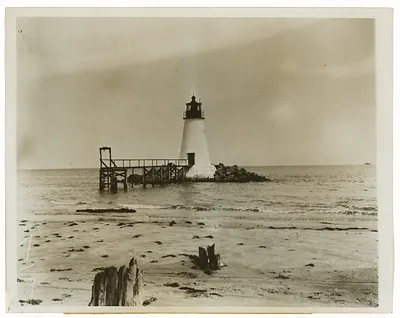 Lighthouse on a wooden pier with sandy beach
