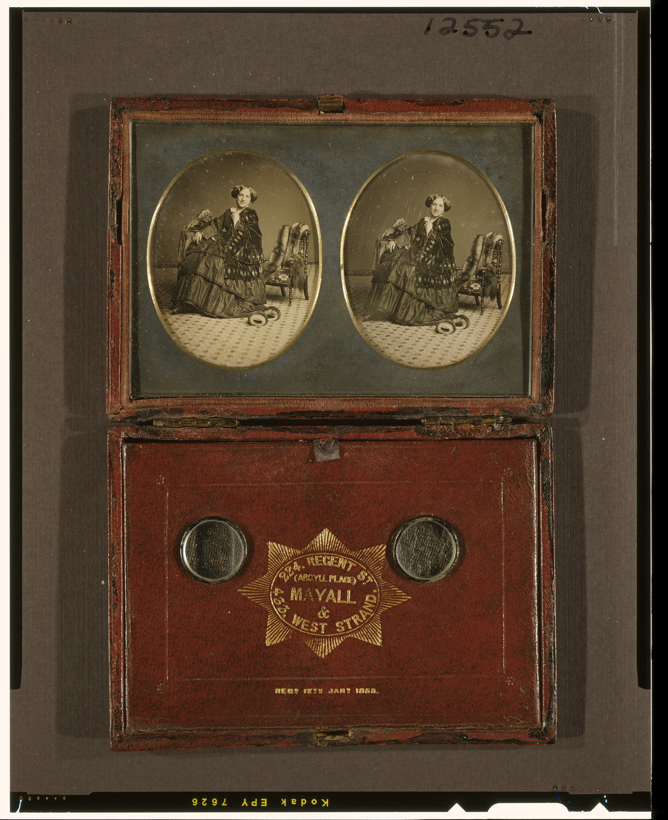 [Stereograph of unidentified woman, full-length, facing front, seated beside chair draped with fur, with fur cuffs (?) on carpeted floor, and bonnet (?) on table with tablecloth], [between 1853 and 1860] — historic photograph