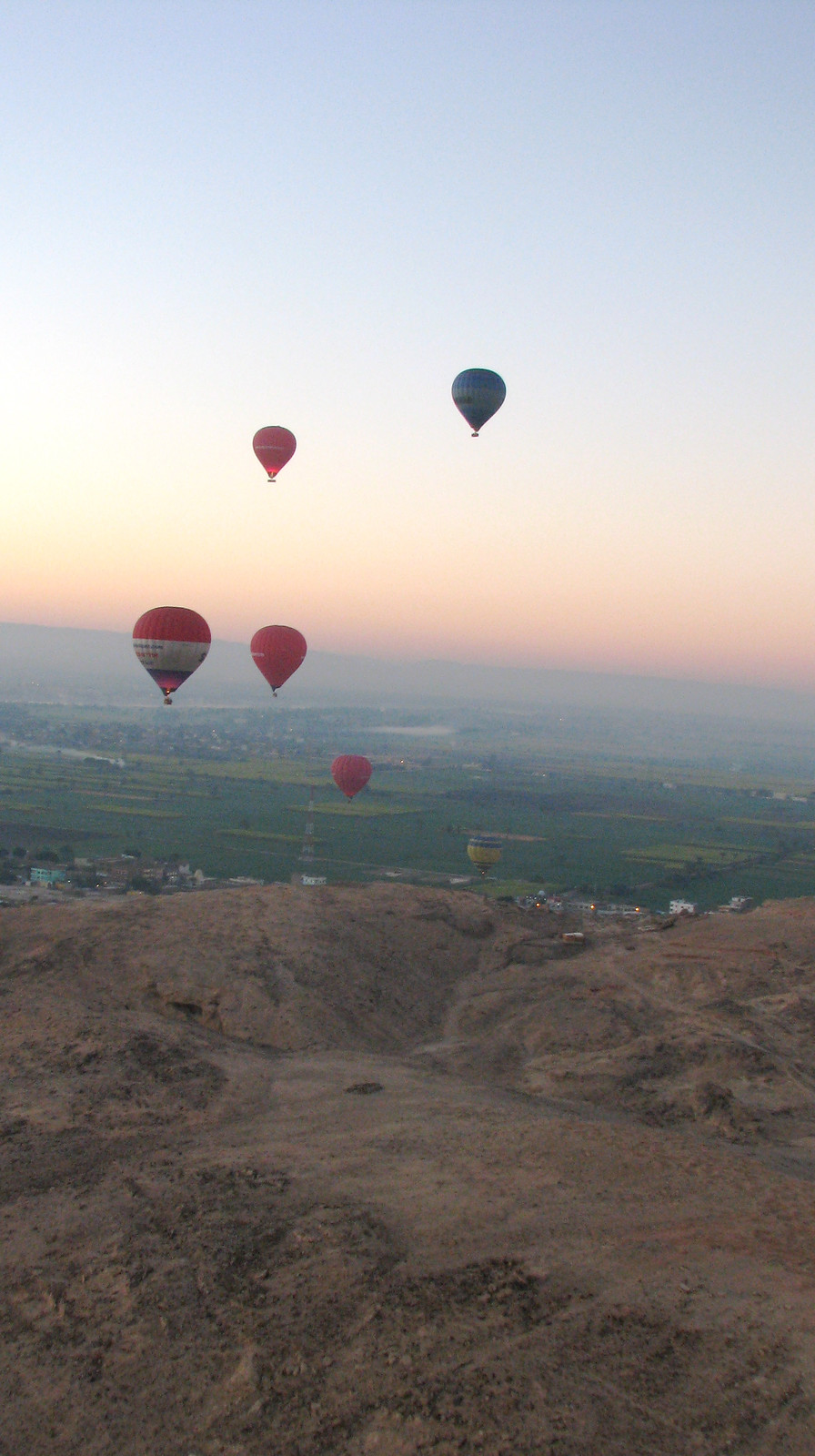 Hot air balloons over farmland and desert hills at dawn — historic image