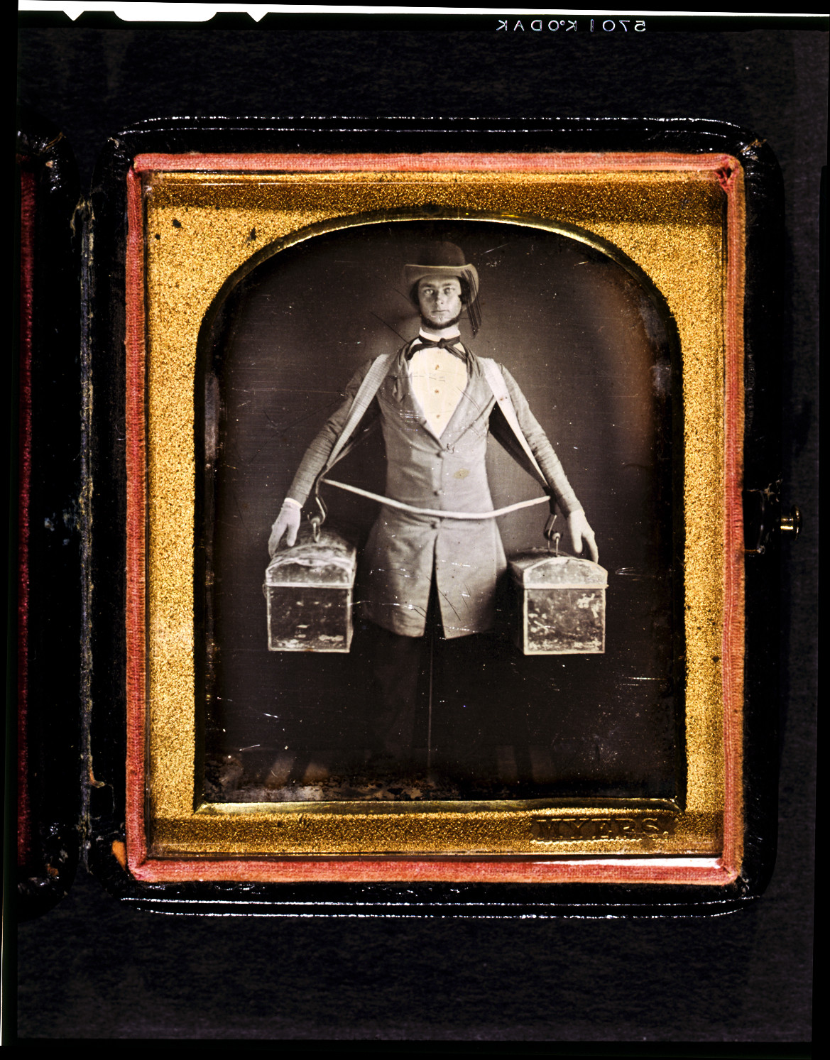 [Occupational portrait of a peddler, full-length, standing, facing front, with two bags held at his sides by a harness, neck brace visible between legs], [between 1840 and 1860] — historic photograph