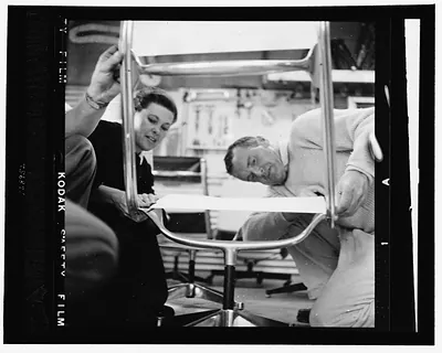 [Charles and Ray Eames examining prototype chair for the aluminum group]