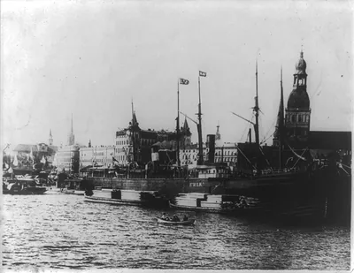 [View of Riga, Latvia with waterfront in foregrd; freighter ERIK and lumber barges]