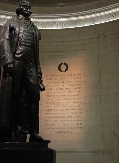 Bronze statue of Thomas Jefferson beside the Declaration inscription