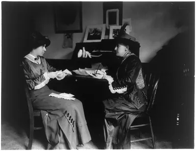 [Mrs. Helen Gardener and Miss Alice Paul, seated, full-length portrait, at desk]