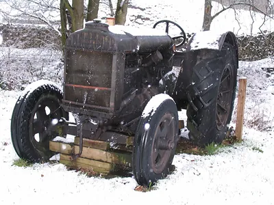 Old black tractor in snow