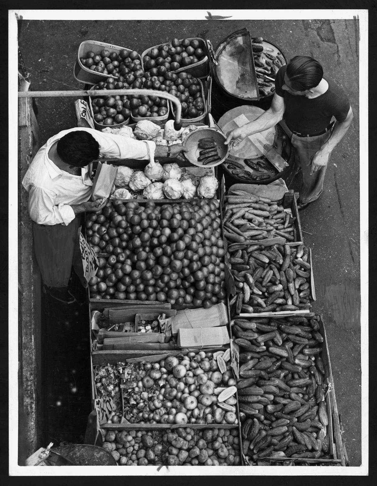 Overhead view of a produce stand with vendors — historic image