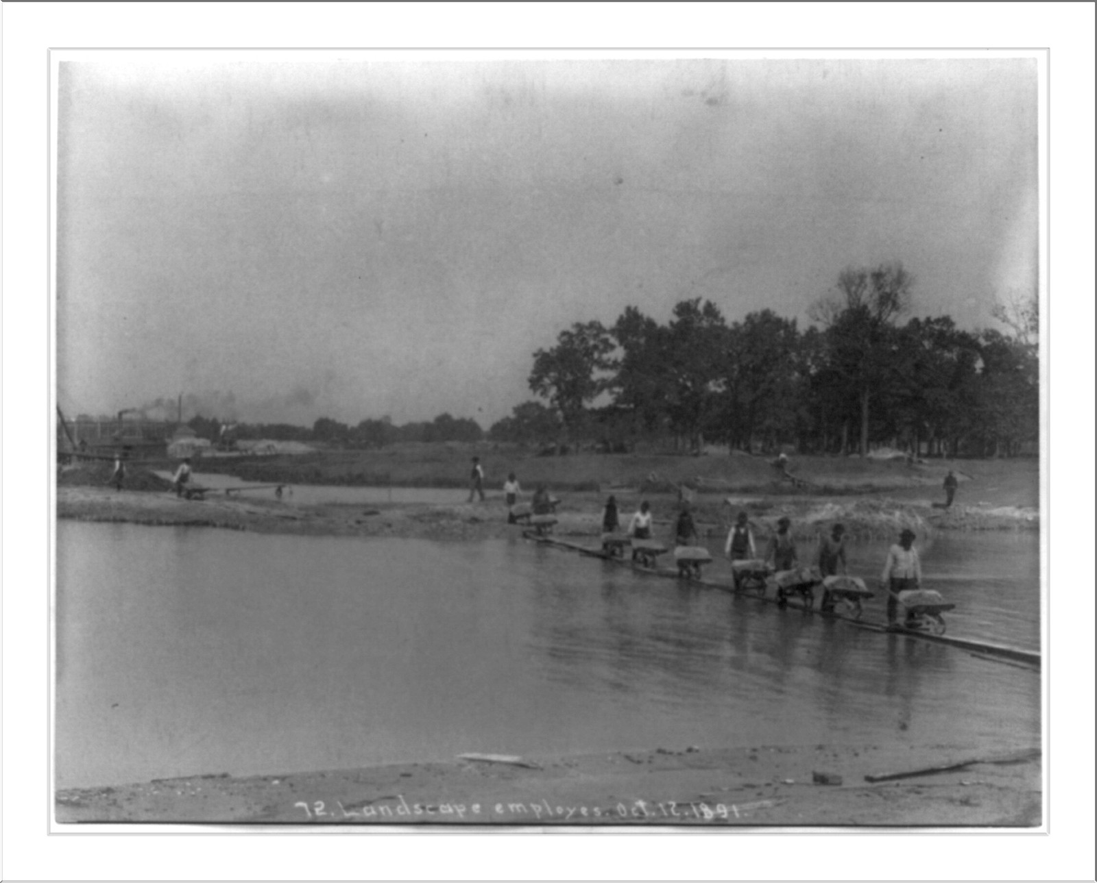 [World's Columbian Exposition, Chicago, under construction: Landscape employees pushing wheelbarrows across body of water], [ca. 1891] — historic photograph
