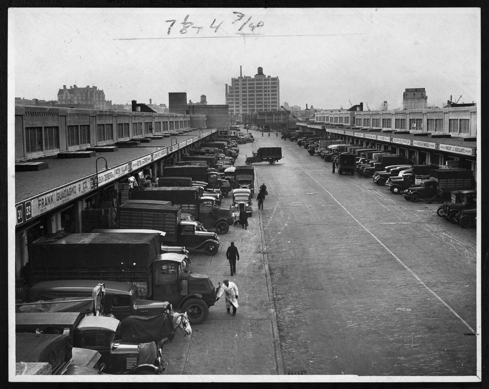 Delivery trucks lined up at a city produce market — historic image