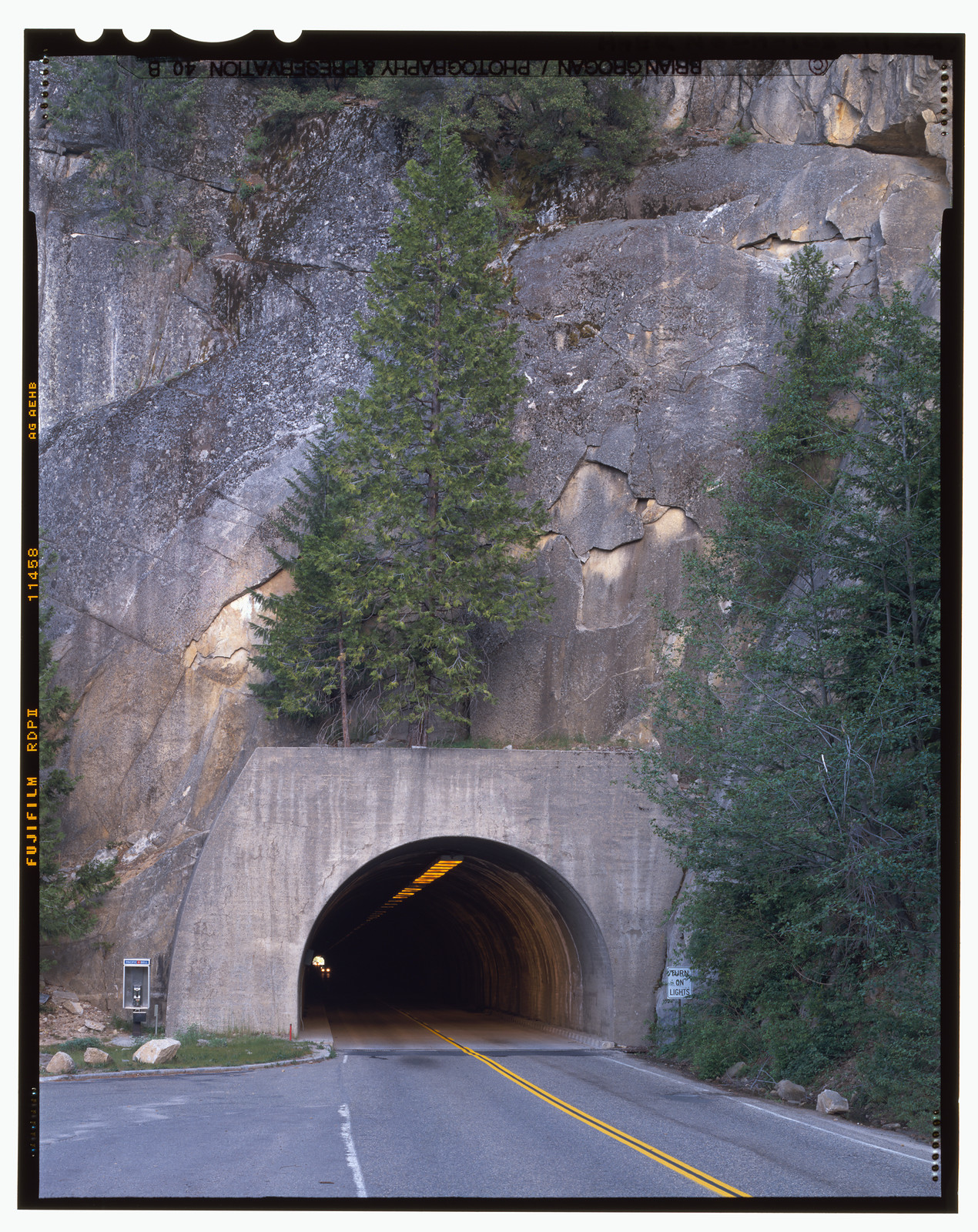 Road entering a concrete tunnel through granite cliffs — historic image
