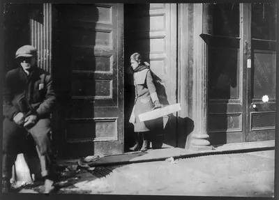 Noon. Girl entering the factory door, 526 W. Broadway, with artificial flowers made at home. Location: New York, New York (State)
