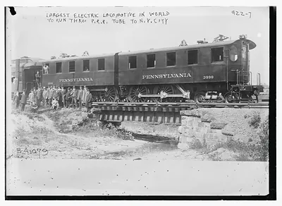 Crowd standing in front of Penn. R.R. car -- the largest electric locomotive in the world, to run through Penn. R.R. tube to N.Y. City