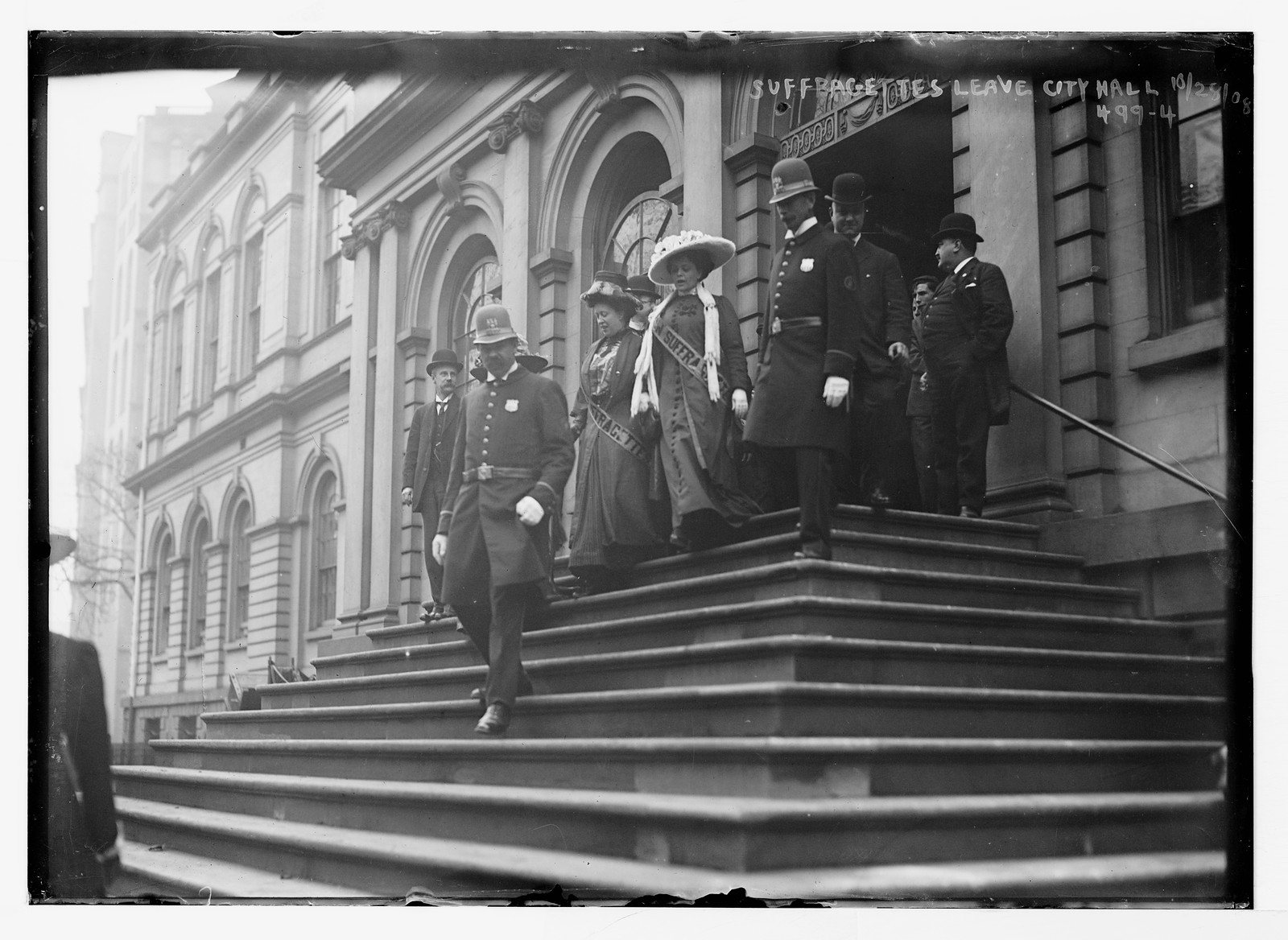 Suffragettes, preceded by policemen, decend steps of City Hall, New York, 10/28/08. — historic photograph