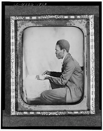 [C.H. Hicks, in profile, seated at desk]