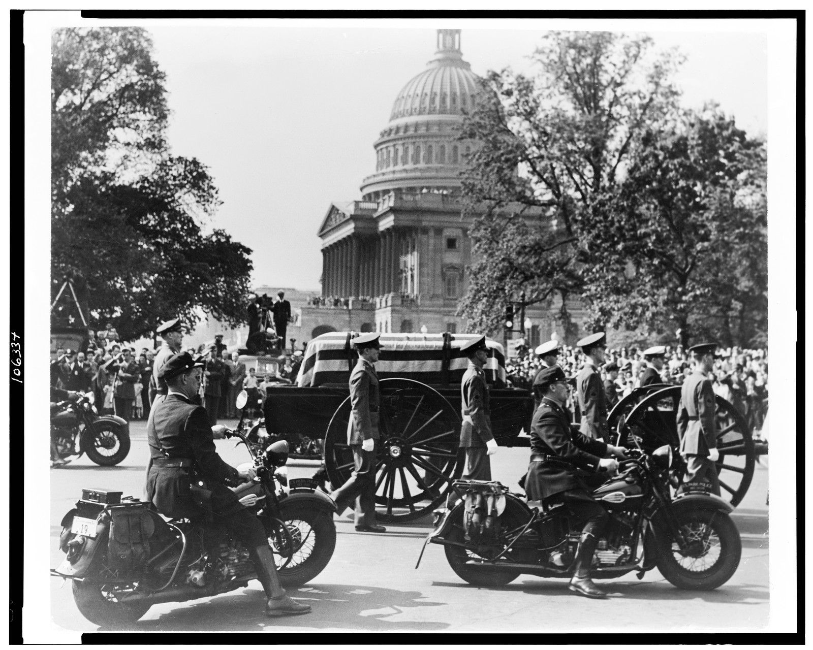 [Funeral of Franklin D. Roosevelt, with casket being moved, motorcycle policemen in foreground, and U.S. Capitol in background], 1945 April 14. — historic photograph