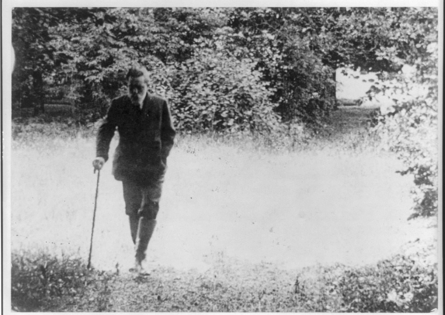 Ex-Kaiser Wilhelm II of Germany walking alone on his estate, with cane in hand, c1922. — historic photograph
