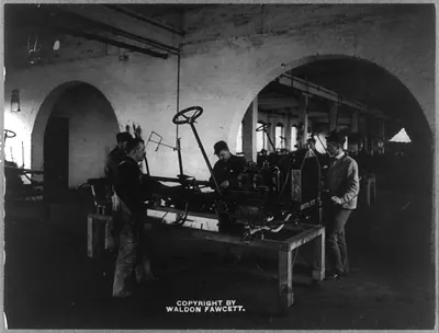 [Men assembling auto in a plant]
