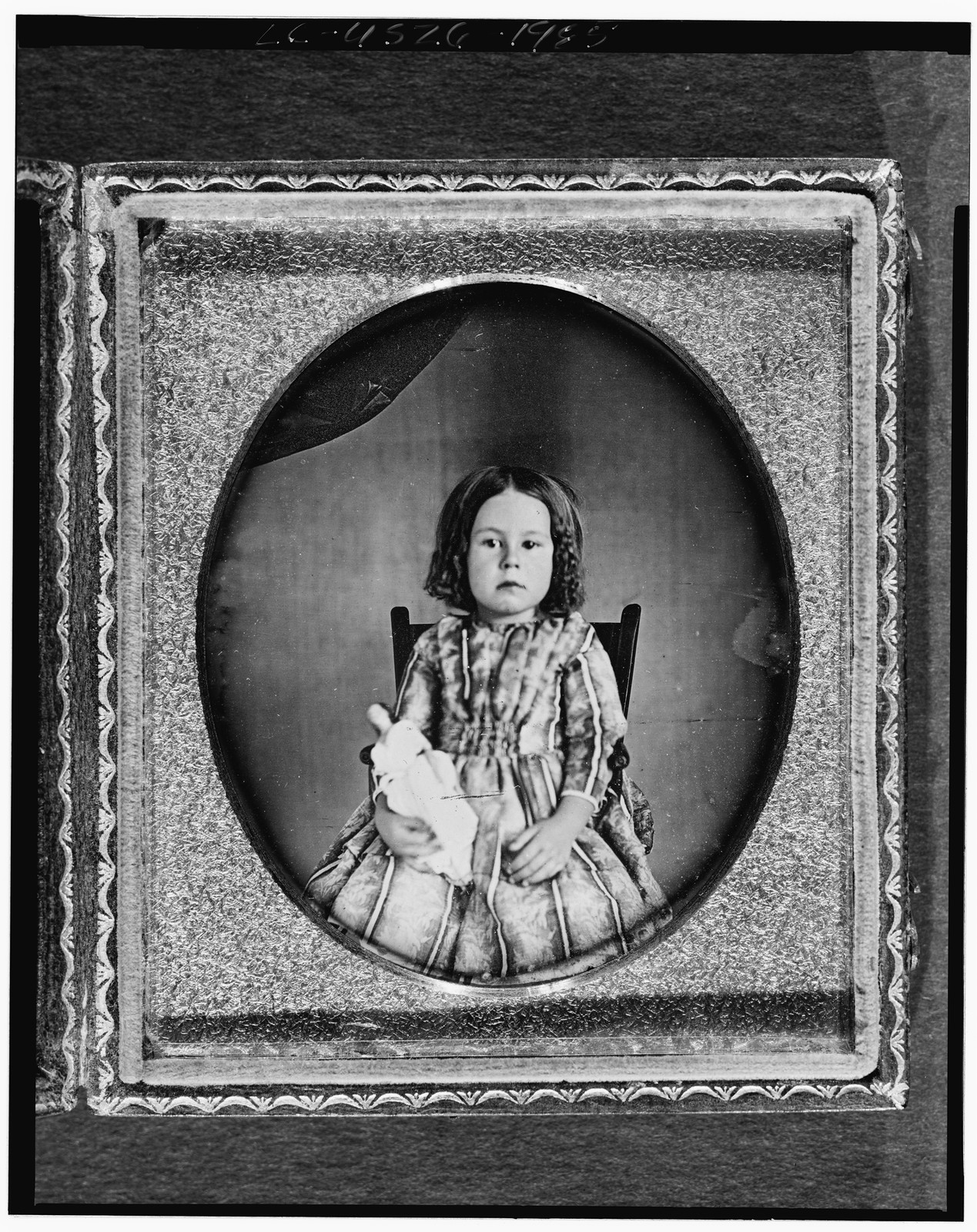 [Unidentified girl, three-quarter length portrait, facing front, seated in chair, holding doll], [between 1842 and 1860] — historic photograph