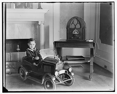 [Child seated in toy automobile]