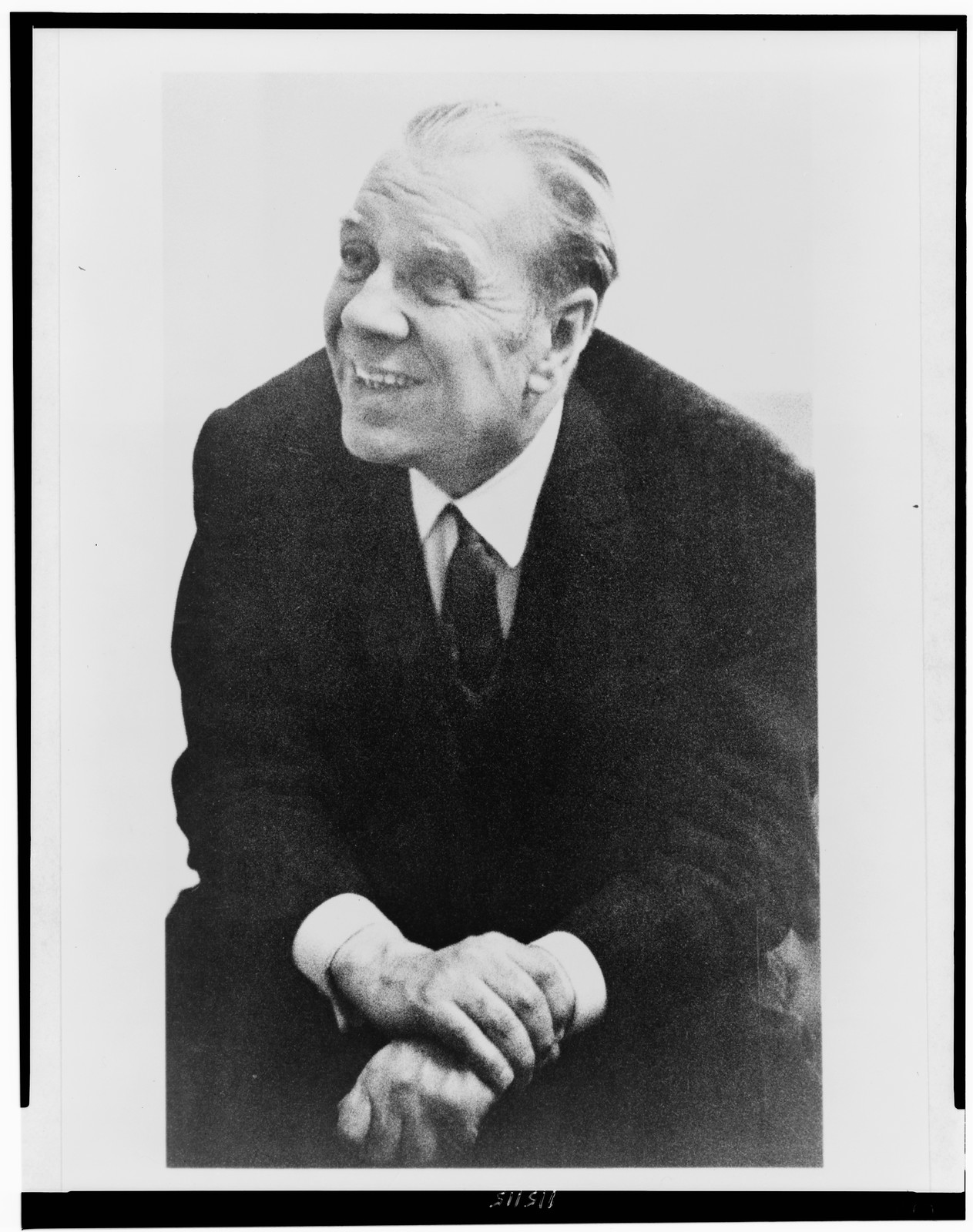 [Jorge Luis Borges, three-quarter length portrait, seated, facing left], 1962 — historic photograph