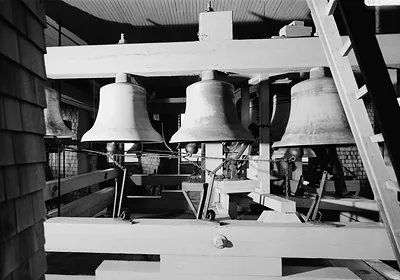 Three bells hung in a wooden belfry frame