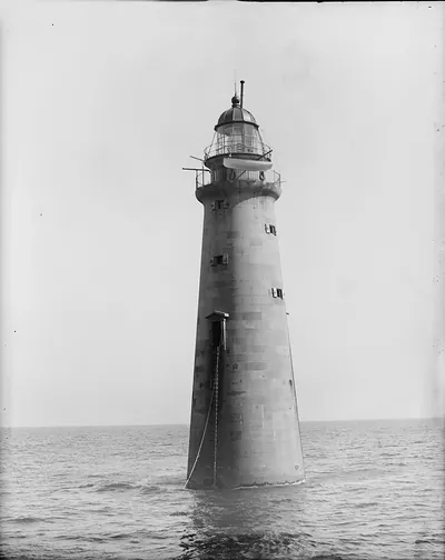 Tapered stone lighthouse rising from calm open sea