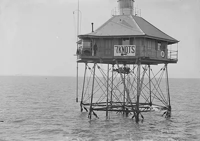Offshore lighthouse on stilts with 7 KNOTS sign
