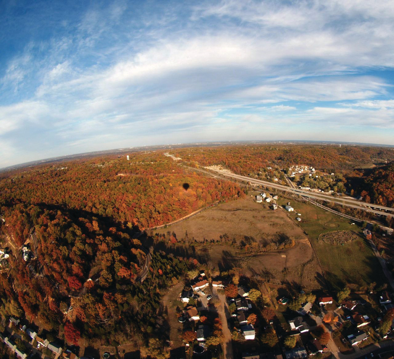 Aerial autumn view of wooded valley and highway — historic image