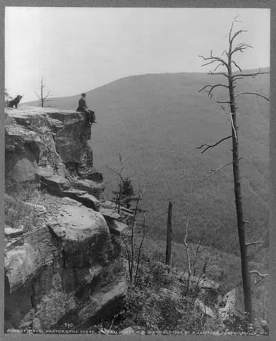 [Men seated on rocks overlooking Catskill Mountains: boulder on South Mountain]