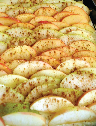 Sliced apples dusted with cinnamon, ready for baking