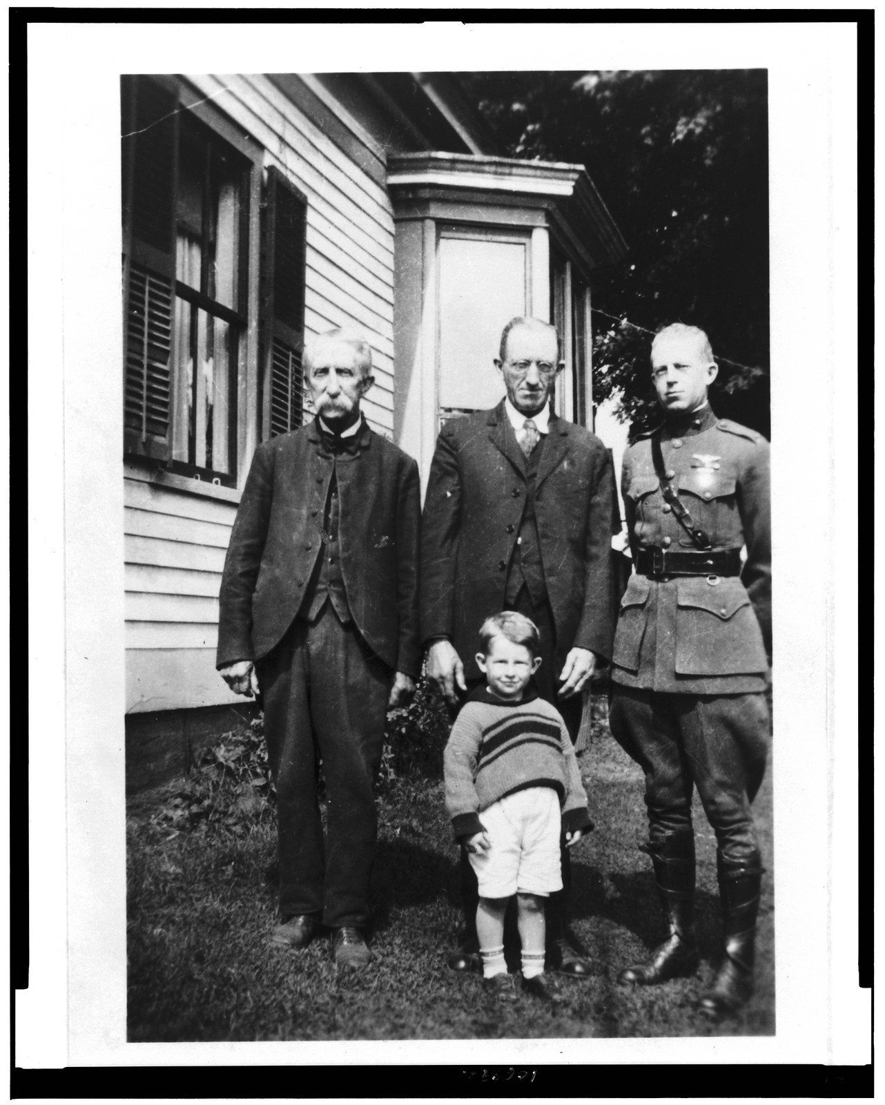 [Merritt Edson, full-length portrait, standing, facing slightly left, in uniform, posed on lawn, with his grandfather, father & son], [ca. 1930] — historic photograph