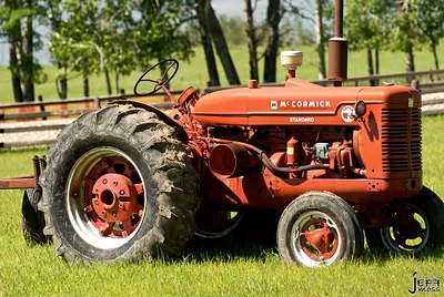 Red McCormick Standard tractor in a grassy field