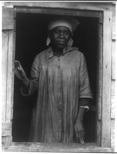 [Negro woman standing in window]