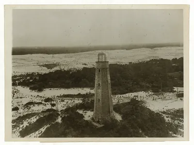 Aerial photograph of a stone lighthouse among dunes and trees