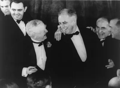 [Franklin D. Roosevelt, in formal dress, embraced by Vice President Garner; they are smiling at each other]