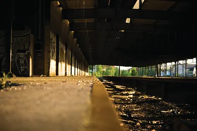 Abandoned industrial hall with concrete platform and debris